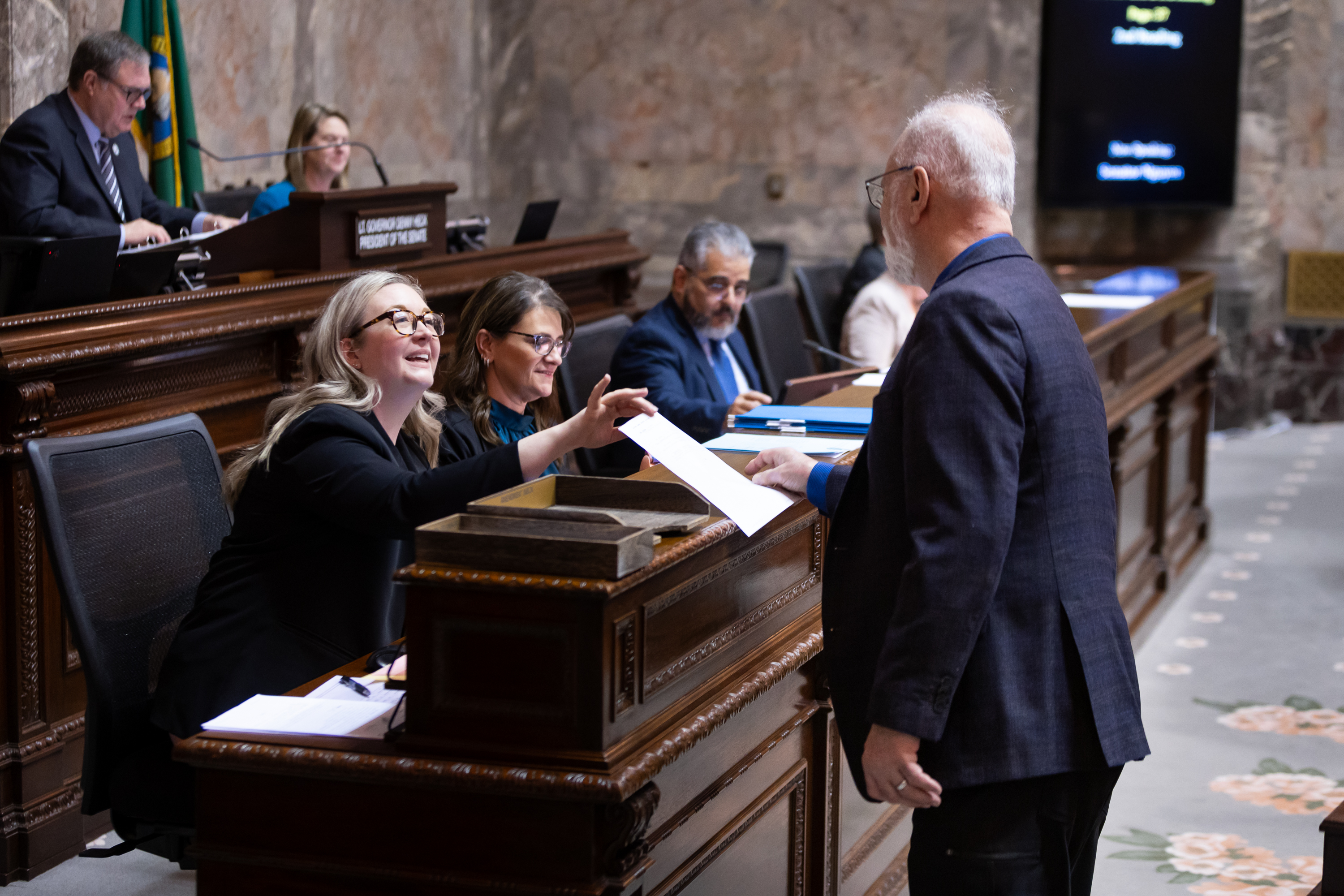 Staff in chamber receives an amendment from a senator